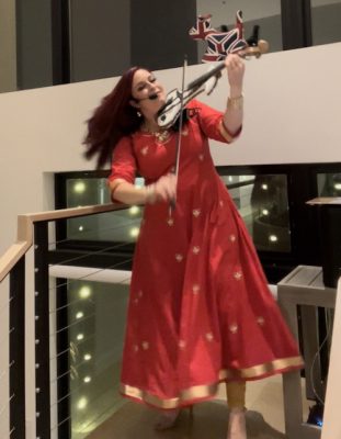 Celeste playing the violin in a red dress